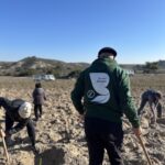 Persona de espaldas en la plantacion del Bosque de los ZAreagozanos con el lem de a sudadera que pone "Yo soy bosque"