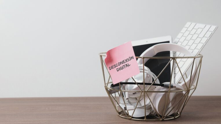 Papelera con un podist que pone Desconexión Digital llena de aparatos digitales