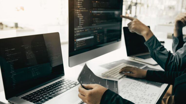 Dos personas trabajando frente a un ordenador, rediseñando una pagina web (frontend)
